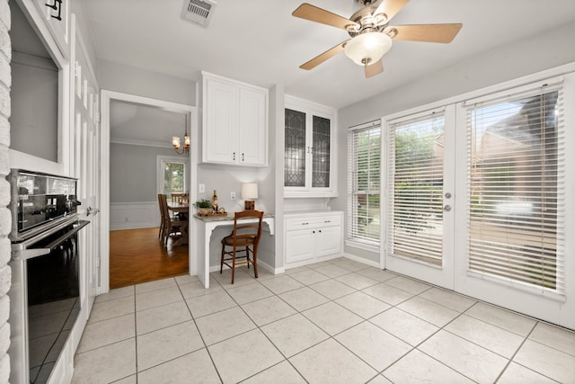 kitchen with white cabinets, light tile patterned floors, and oven