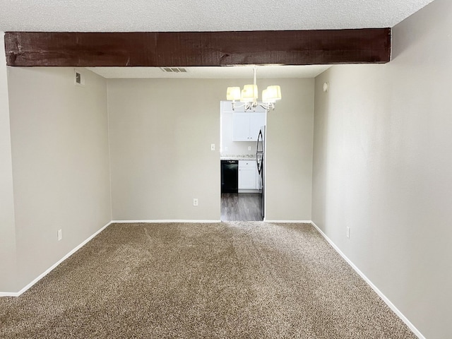 unfurnished room with dark carpet, beamed ceiling, a chandelier, and a textured ceiling