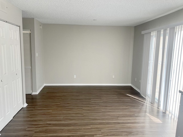 interior space with a textured ceiling, a closet, and dark wood-type flooring