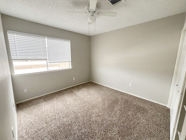 empty room featuring ceiling fan, a textured ceiling, and carpet flooring