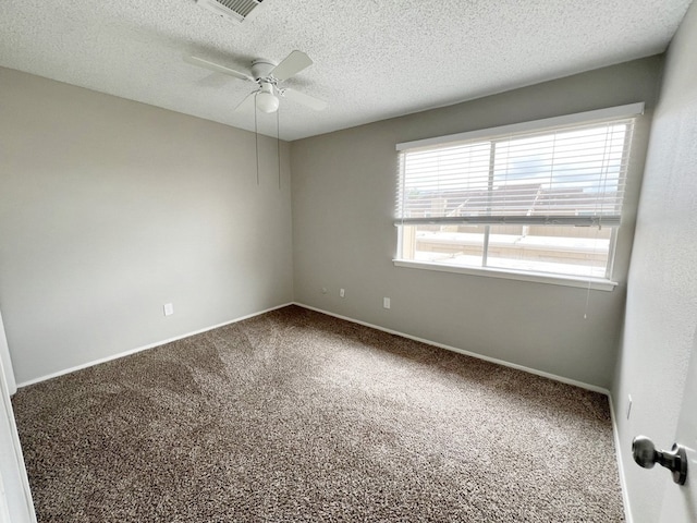 carpeted spare room with ceiling fan and a textured ceiling