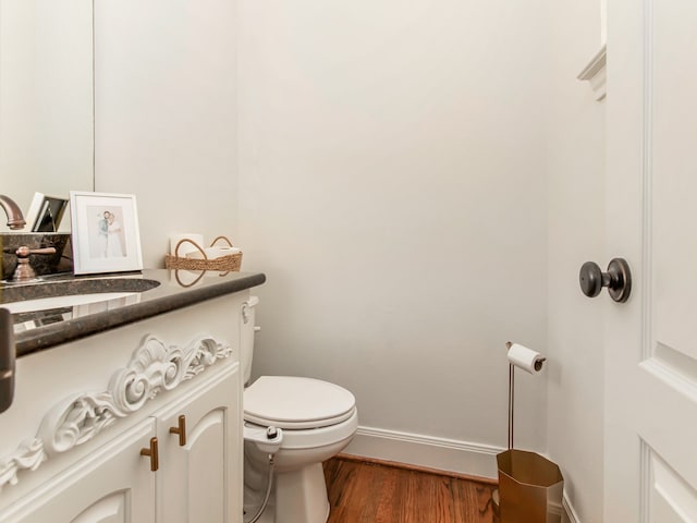 bathroom featuring vanity, toilet, and hardwood / wood-style floors