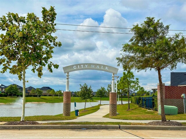 view of property's community featuring a lawn and a water view