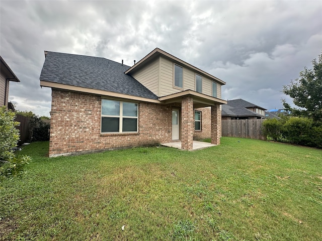 rear view of property with a lawn and a patio area