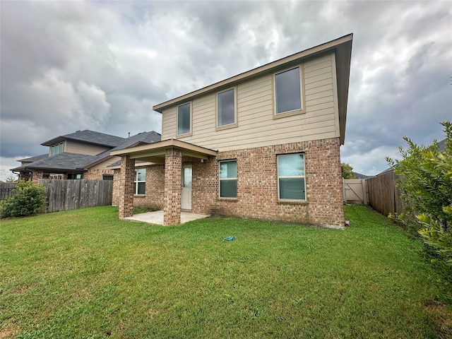 rear view of house with a lawn and a patio