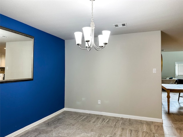 spare room featuring an inviting chandelier