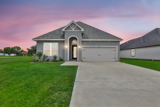 view of front of property featuring a garage and a lawn