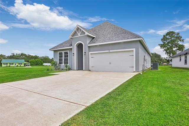 view of front of home with central AC, a front yard, and a garage