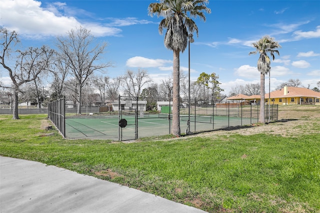 view of tennis court with a yard