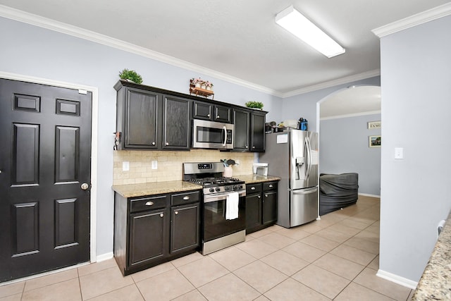 kitchen with light stone countertops, stainless steel appliances, light tile patterned flooring, and ornamental molding