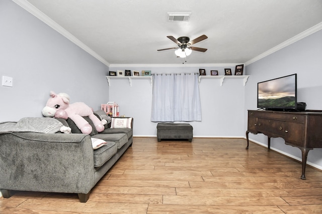 living room featuring ceiling fan, light hardwood / wood-style floors, and crown molding