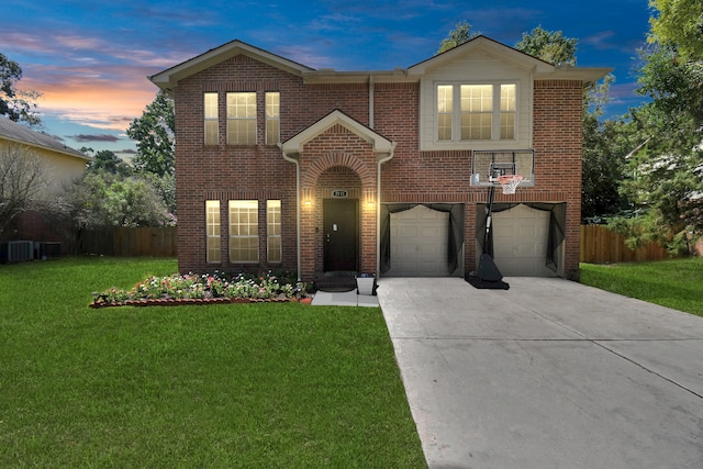 view of front of home featuring cooling unit, a yard, and a garage