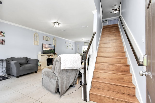 staircase featuring crown molding and tile patterned floors