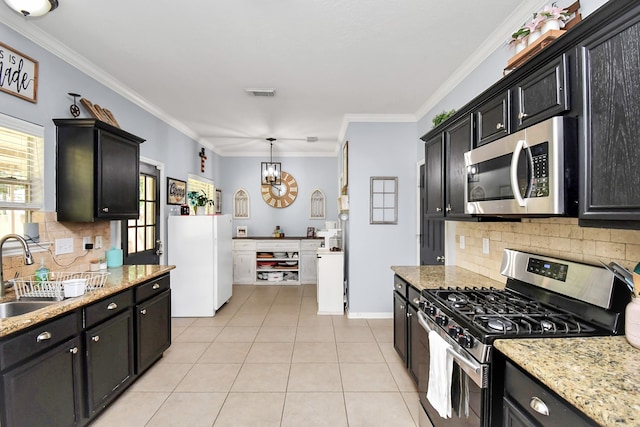 kitchen featuring crown molding, tasteful backsplash, light tile patterned floors, sink, and appliances with stainless steel finishes