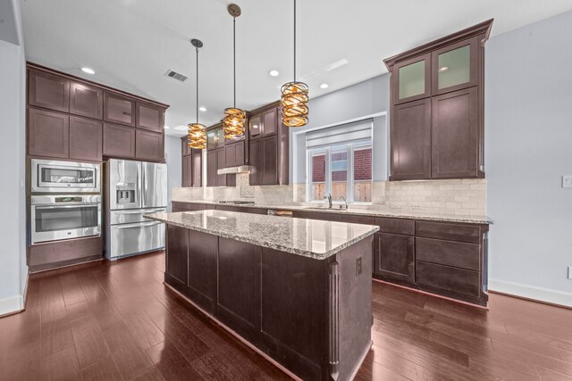 kitchen featuring pendant lighting, stainless steel appliances, dark hardwood / wood-style floors, and a kitchen island