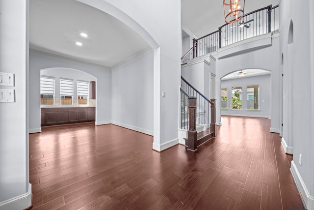 foyer entrance featuring ornamental molding, dark hardwood / wood-style floors, and ceiling fan with notable chandelier