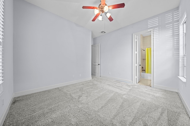 unfurnished bedroom featuring ceiling fan, light carpet, and ensuite bathroom