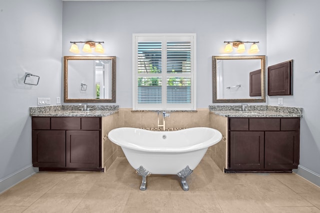 bathroom featuring vanity, a washtub, and tile patterned floors