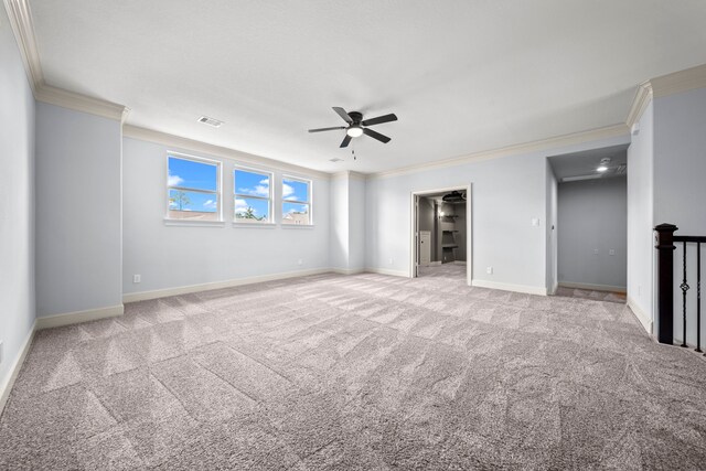 spare room featuring ceiling fan, ornamental molding, and light carpet