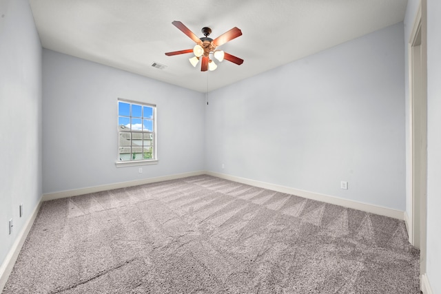 carpeted spare room featuring ceiling fan