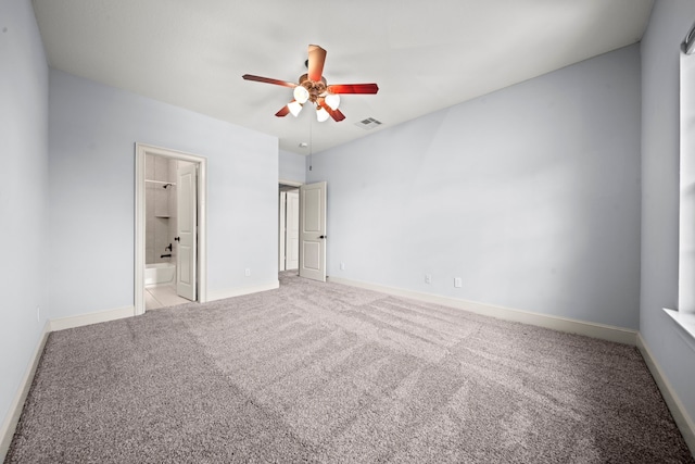 unfurnished bedroom featuring a spacious closet, light carpet, and ceiling fan