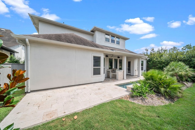 rear view of house featuring ceiling fan, area for grilling, a yard, and a patio area