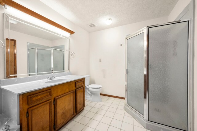 bathroom with toilet, tile patterned flooring, a shower with door, vanity, and a textured ceiling