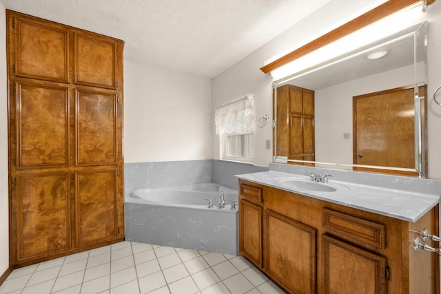 bathroom with tile patterned floors, a washtub, a textured ceiling, and vanity