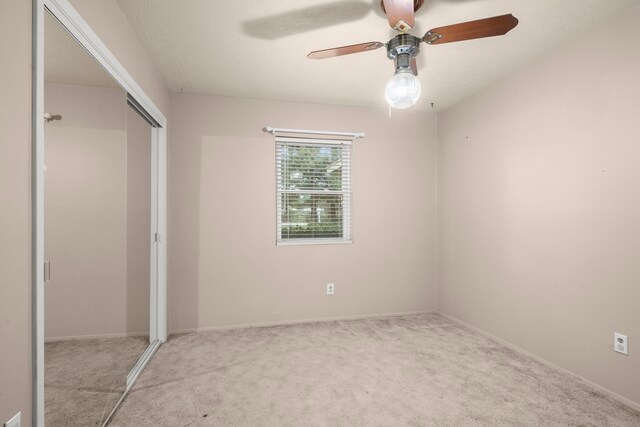 unfurnished bedroom with a closet, ceiling fan, and carpet