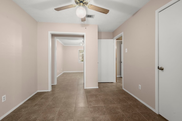 empty room featuring ceiling fan and ornamental molding