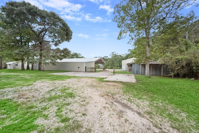 view of yard with a carport and an outbuilding