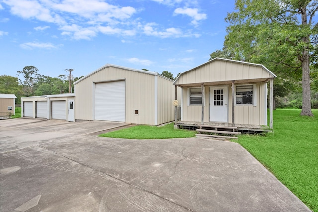 view of front facade with a garage, a front lawn, and an outbuilding