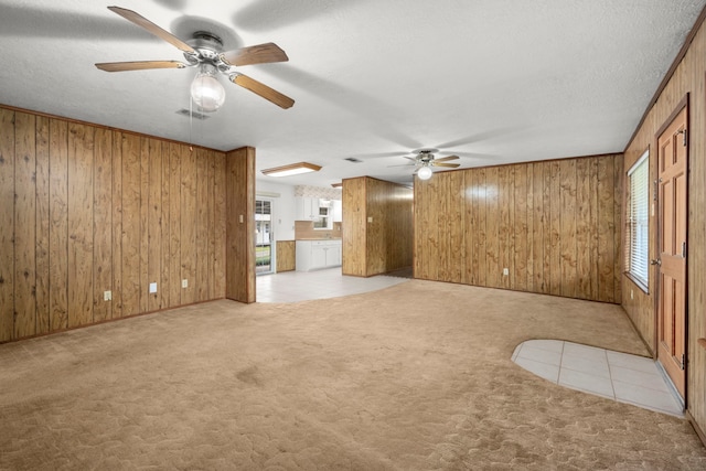 unfurnished room featuring ceiling fan, a wealth of natural light, and light colored carpet