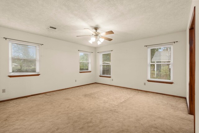 carpeted empty room with a textured ceiling and ceiling fan