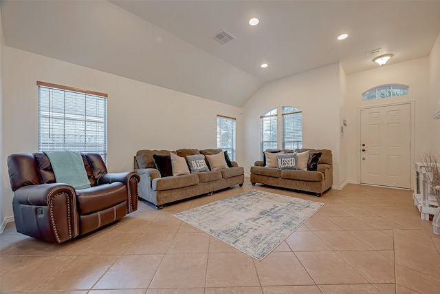 living room with plenty of natural light, light tile patterned flooring, and vaulted ceiling