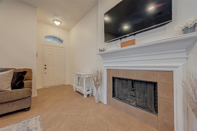 tiled entrance foyer featuring a tiled fireplace and vaulted ceiling