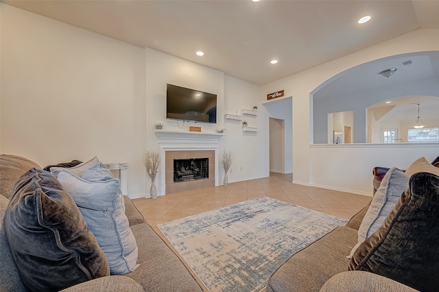 living room with lofted ceiling, light tile patterned floors, and a tile fireplace