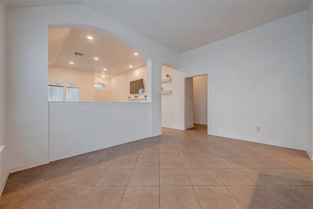 unfurnished living room with lofted ceiling and light tile patterned floors