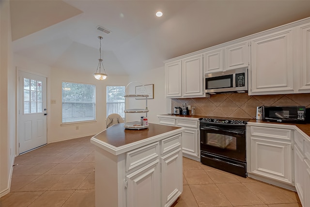 kitchen with vaulted ceiling, black electric range, backsplash, a center island, and light tile patterned flooring