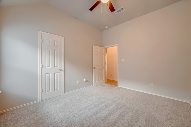 unfurnished bedroom with light colored carpet, lofted ceiling, ceiling fan, and a closet