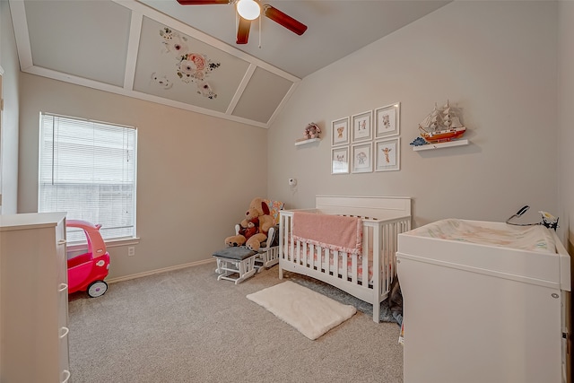 bedroom with a nursery area, light carpet, vaulted ceiling, and ceiling fan