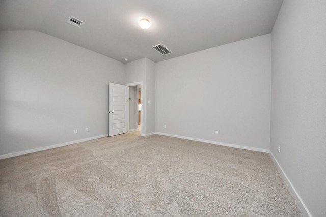 carpeted spare room with vaulted ceiling