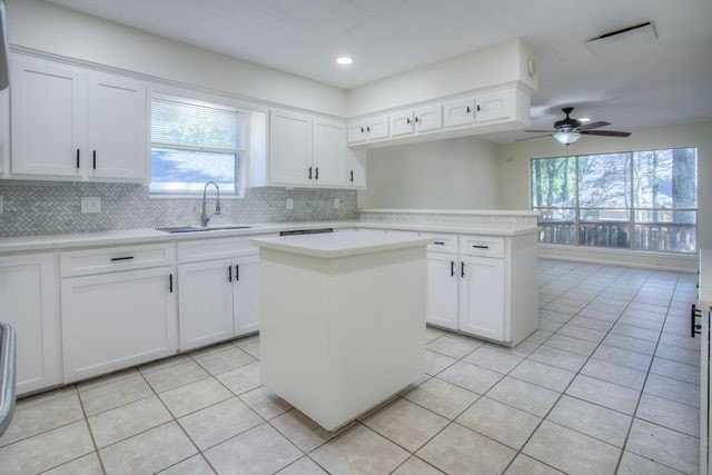 kitchen with light tile patterned floors, a wealth of natural light, a sink, and light countertops