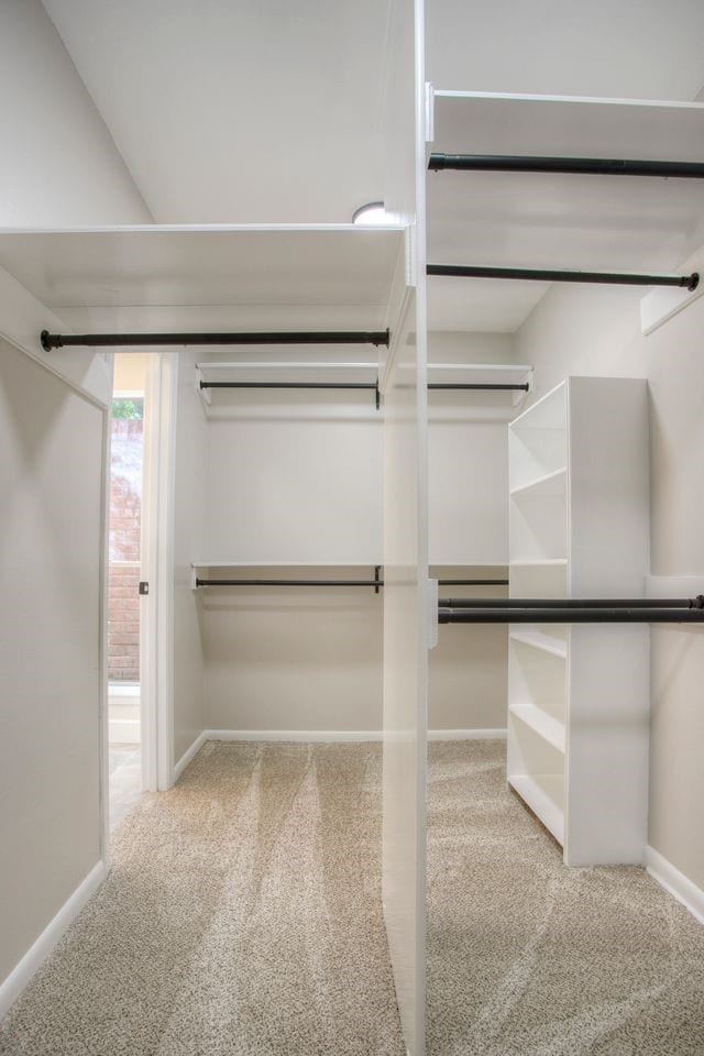 walk in closet featuring light carpet