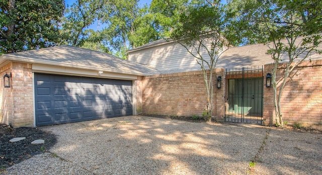 view of front of home featuring aphalt driveway, brick siding, and a garage