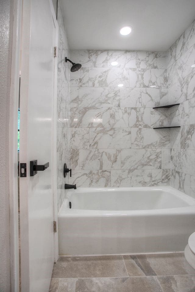 bathroom with toilet and  shower combination