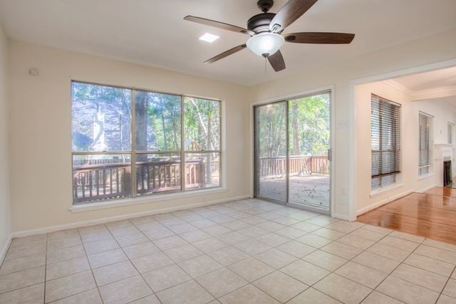 empty room featuring light tile patterned floors, baseboards, and ceiling fan