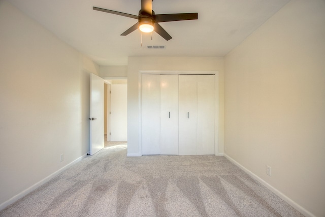 unfurnished bedroom featuring a closet, ceiling fan, carpet, baseboards, and visible vents