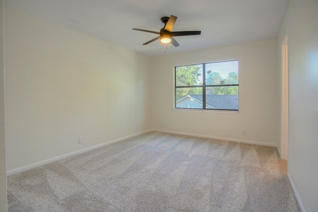 carpeted empty room with ceiling fan and baseboards