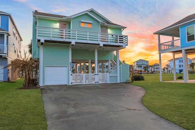 view of front of house featuring a yard, a garage, and a balcony